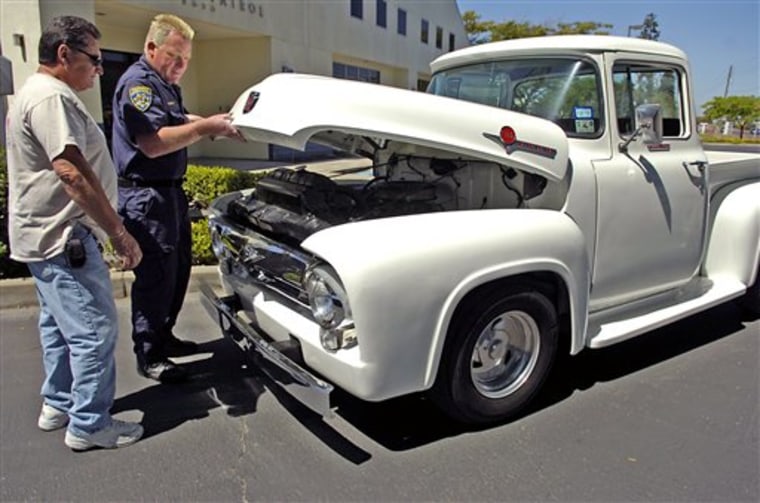 California Highway Patrol Officer Greg Bennett and Harold Voelker take a look at Voelker's 1956 Ford F-100 truck, which was stolen from him in 1972. 
